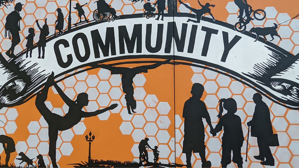 Orange mural with the word 'Community' featuring silhouettes of different people.